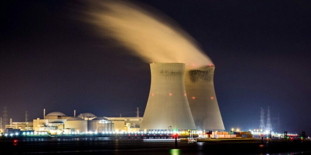 Atomkraftwerk in Belgien bei Nacht, Lichter am Horizont, Dampf aus den Kühltürmen