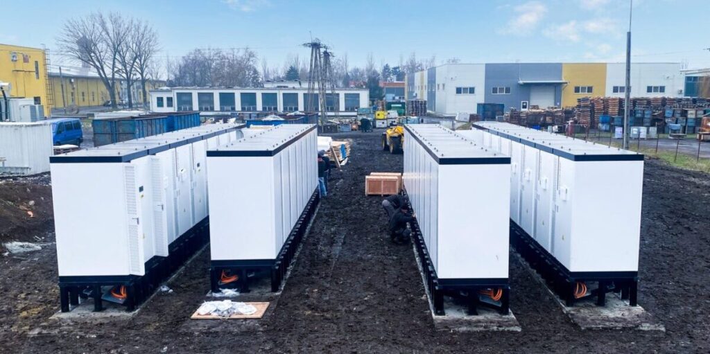 Speicher in Feld, weiße Container in Industrie Gebiet. MAtschiger Boden blauer Himmel