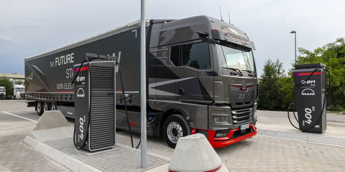 Ein elektrischer Lkw steht zwischen zwei Schnellladestationen von Alpitronic.