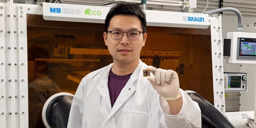 Erstautor Dr Kun Sun hält eine Perovskit-Solarzelle in der Hand.