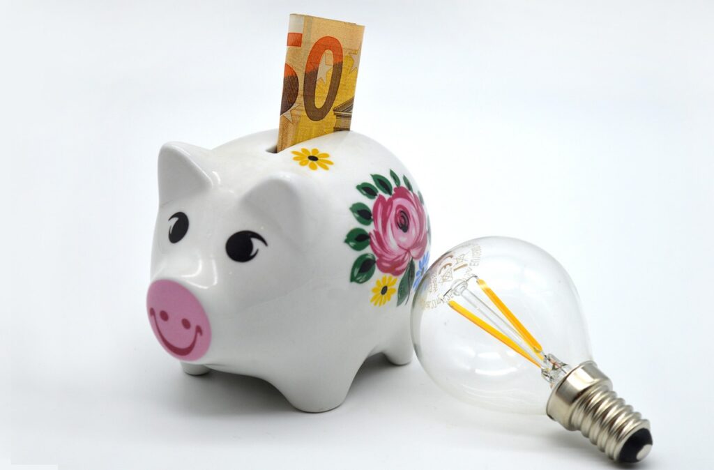Sparschwein, Geldschein und Glühlampe
