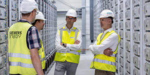 Menschen im Raum. Silbern industriell mit racks voller Superkon densatoren