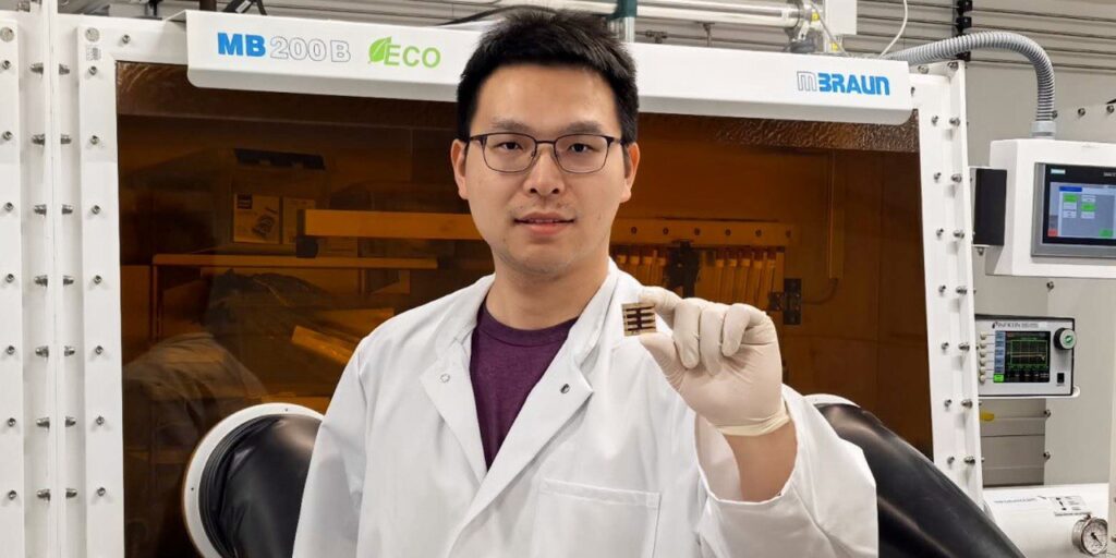 Erstautor Dr Kun Sun hält eine Perovskit-Solarzelle in der Hand.
