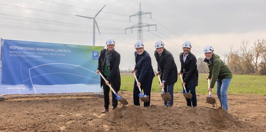 Spatenstich in freien Feld. Erdhaufen, Strommast