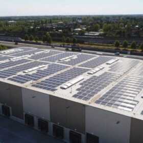 Große Photovoltaik-Dachanlage auf Gewerbehalle nahe der Autobahn