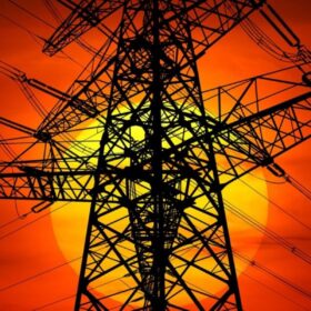 Stromnetz - Mast mit Leitungen vor untergehender Sonne