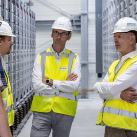 Menschen im Raum. Silbern industriell mit racks voller Superkon densatoren